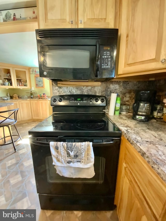 kitchen featuring black appliances, decorative backsplash, and light brown cabinetry