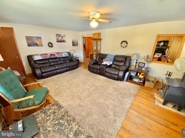 living room with wood finished floors and a ceiling fan