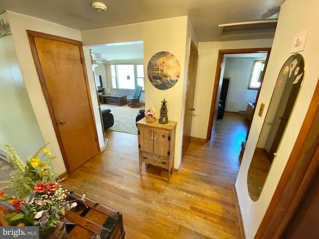 hallway with light wood finished floors and baseboards