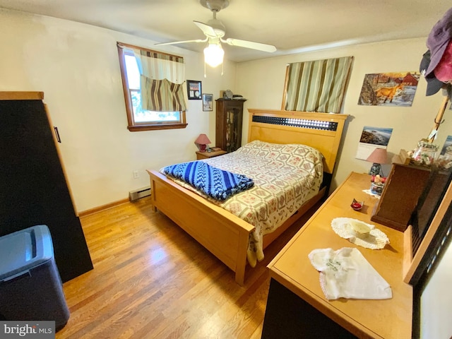 bedroom with light wood-style flooring, a baseboard heating unit, ceiling fan, and baseboards