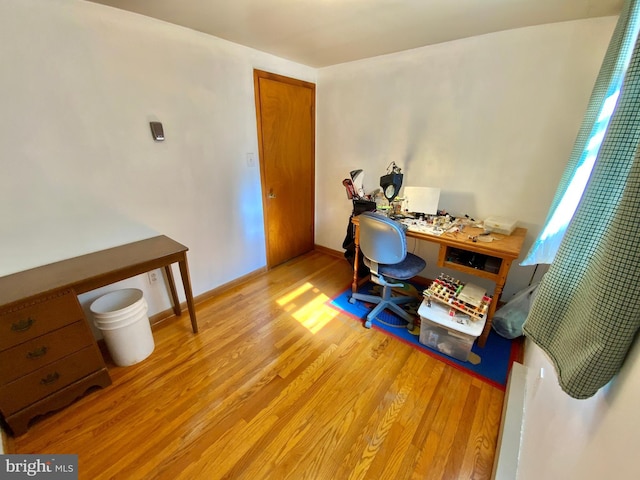 office space with light wood-type flooring and baseboards