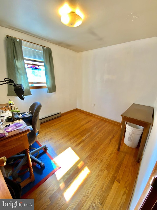 office area featuring baseboards, baseboard heating, and wood finished floors