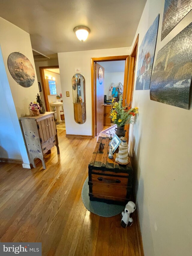 corridor featuring wood finished floors and baseboards