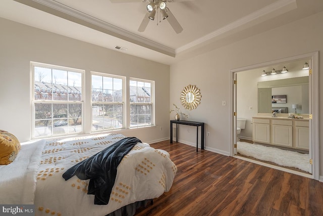 bedroom featuring visible vents, dark wood finished floors, a raised ceiling, crown molding, and a sink