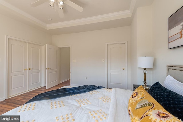 bedroom with ornamental molding, a closet, wood finished floors, and a ceiling fan