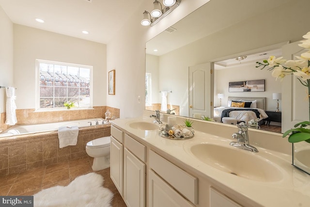 ensuite bathroom featuring a garden tub, ensuite bath, a sink, and tile patterned floors