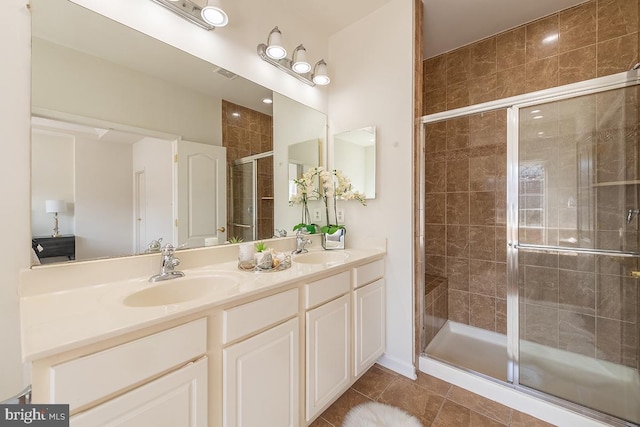 bathroom with double vanity, a sink, visible vents, and a shower stall