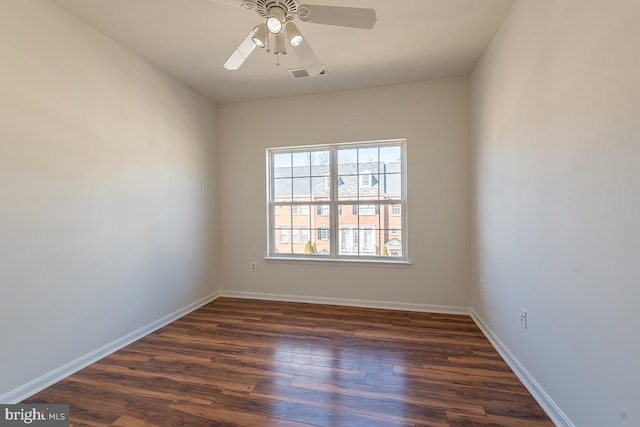 empty room with dark wood-type flooring, visible vents, ceiling fan, and baseboards