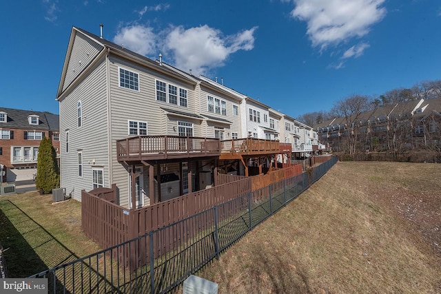 rear view of house with central AC, fence, a deck, and a lawn