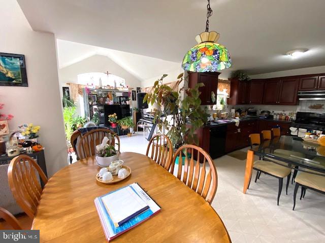 dining room featuring lofted ceiling and light floors