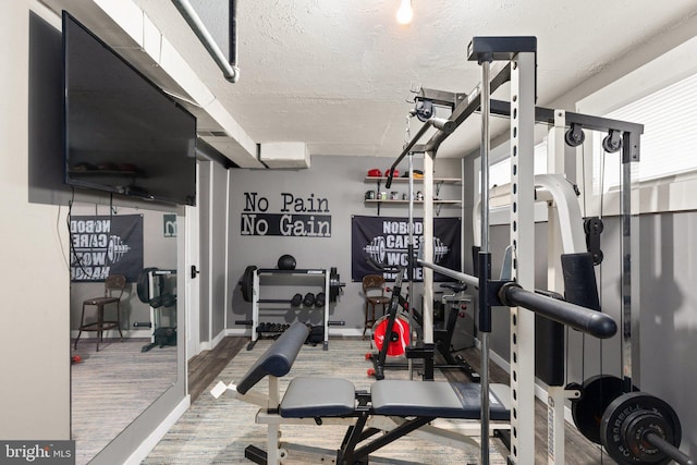 workout room with a textured ceiling and wood finished floors