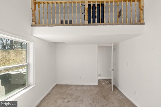 spare room with carpet flooring, visible vents, and baseboards