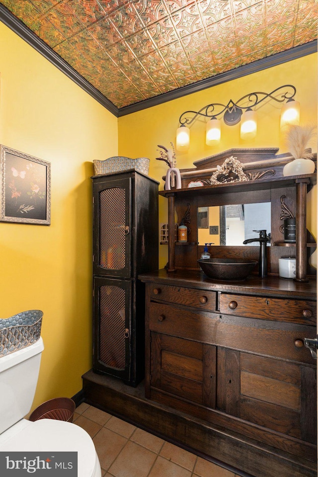 half bath featuring an ornate ceiling, toilet, ornamental molding, and vanity