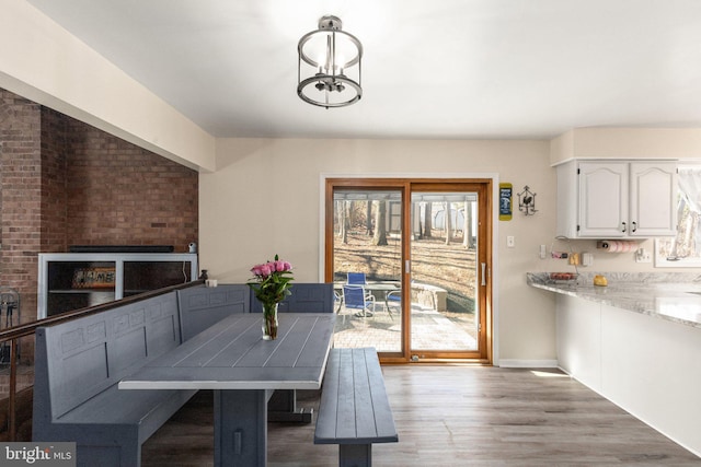 dining room featuring a notable chandelier, light wood-style flooring, and baseboards