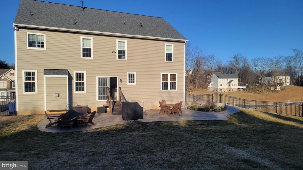 back of house with a patio, a lawn, roof with shingles, and a fenced backyard