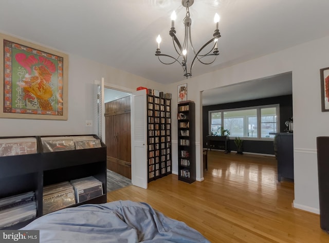 interior space with baseboards, a notable chandelier, and wood finished floors