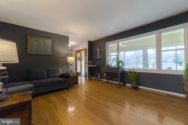 living area with baseboards and light wood finished floors