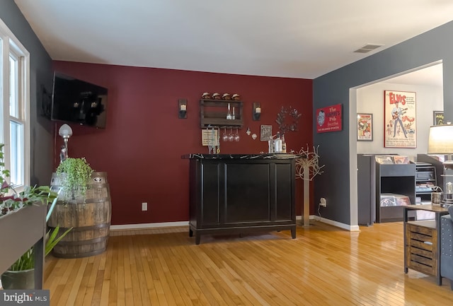 bar with visible vents, baseboards, and wood-type flooring