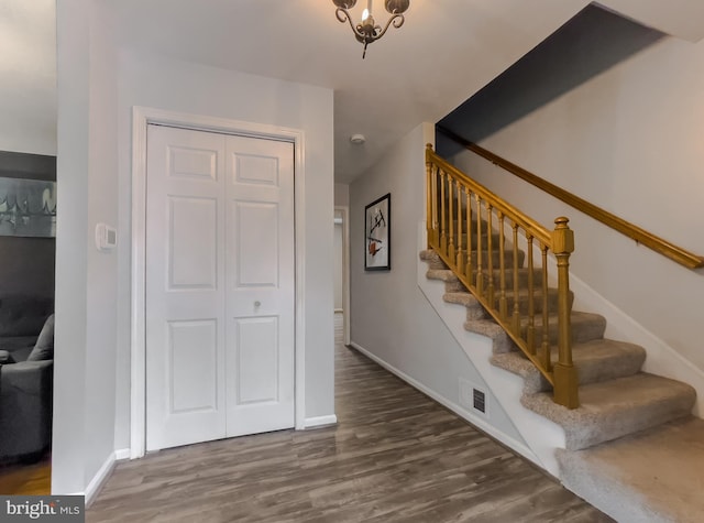 stairs with visible vents, baseboards, and wood finished floors