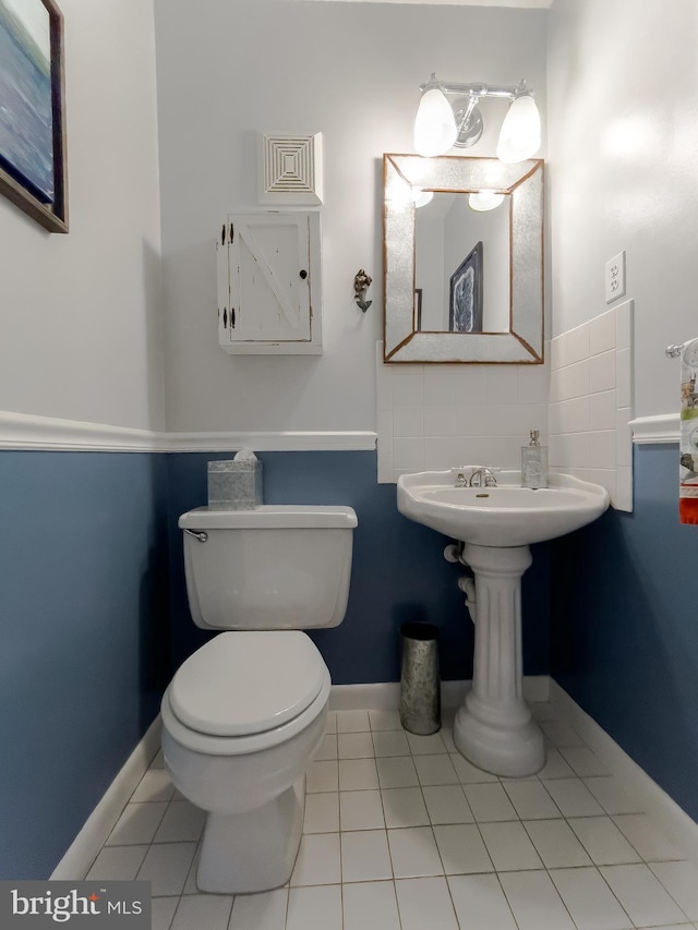 bathroom featuring tile patterned floors, toilet, and baseboards