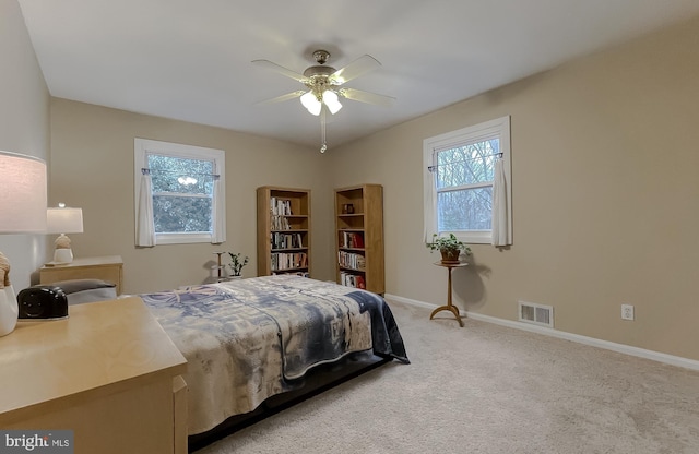 bedroom with visible vents, light carpet, multiple windows, and baseboards