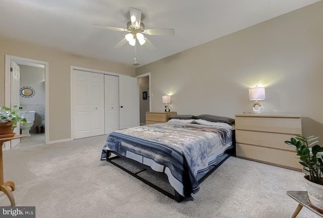 bedroom featuring connected bathroom, a closet, baseboards, light colored carpet, and ceiling fan