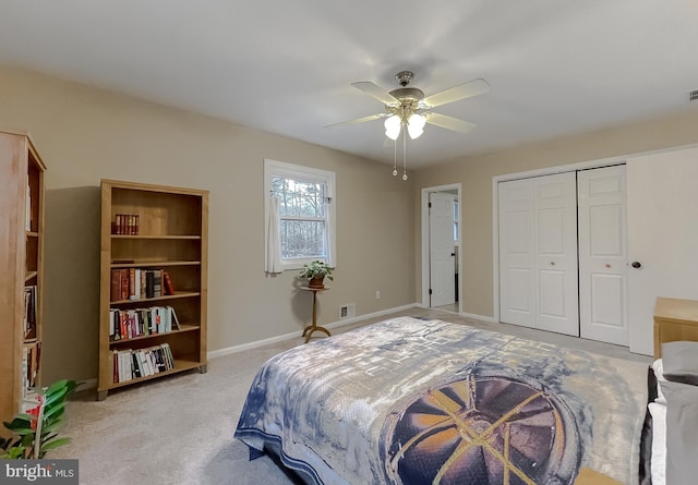 bedroom featuring visible vents, baseboards, ceiling fan, a closet, and light colored carpet