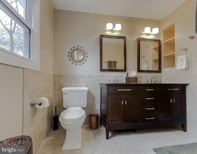 bathroom with a sink, toilet, tile walls, and tile patterned flooring