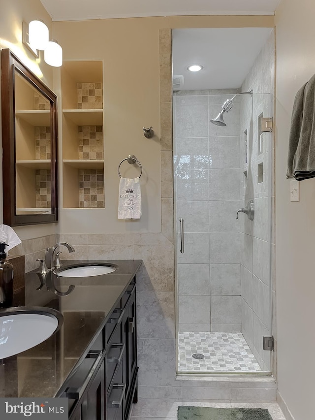 full bath with a sink, a stall shower, and double vanity