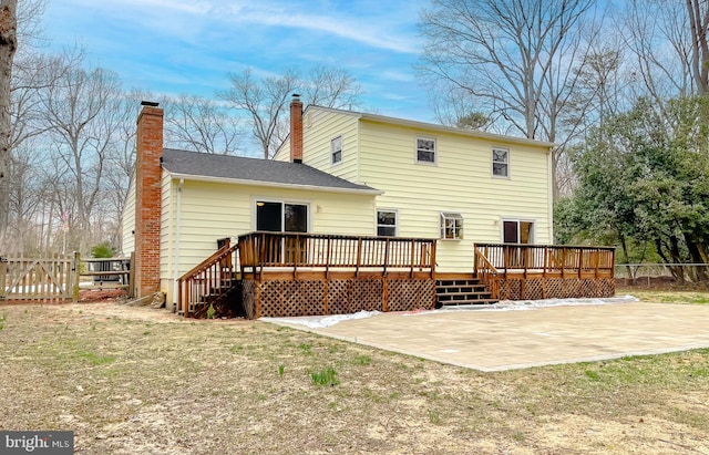 back of house with a patio, a deck, a chimney, and fence