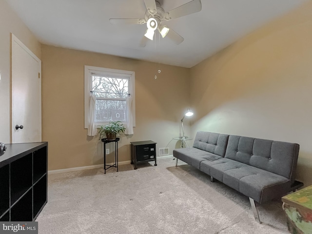 living area featuring visible vents, baseboards, carpet, and ceiling fan