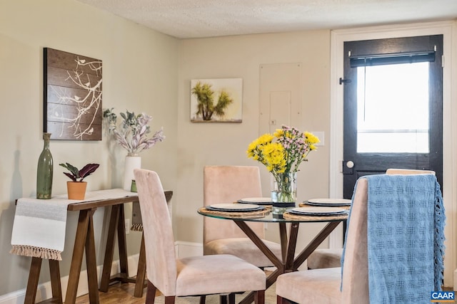 dining area with baseboards and a textured ceiling