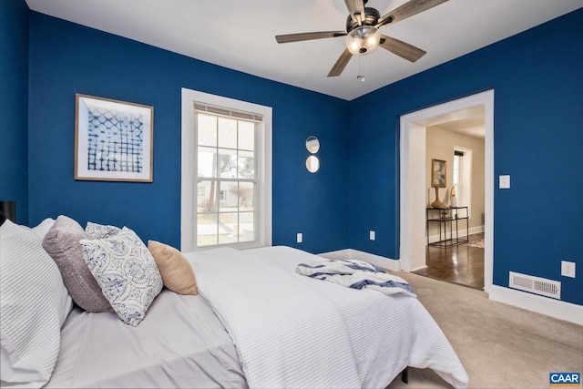 bedroom featuring carpet floors, visible vents, baseboards, and a ceiling fan