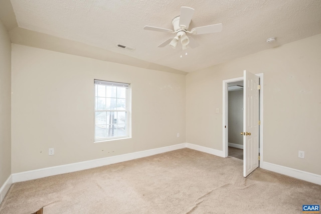 unfurnished bedroom with light carpet, a textured ceiling, visible vents, and baseboards