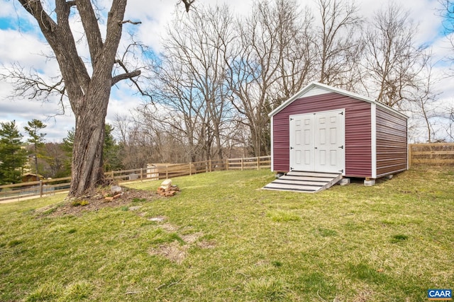 view of yard featuring a shed, a fenced backyard, and an outdoor structure