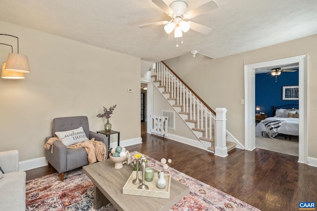 living area featuring visible vents, stairway, a textured ceiling, and wood finished floors