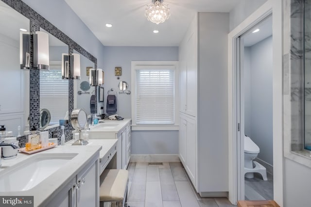 bathroom featuring baseboards, toilet, a shower with shower door, vanity, and recessed lighting