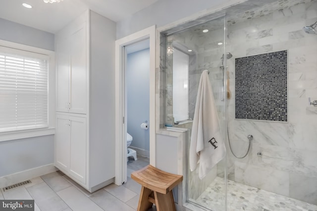 bathroom featuring a stall shower, baseboards, visible vents, and toilet