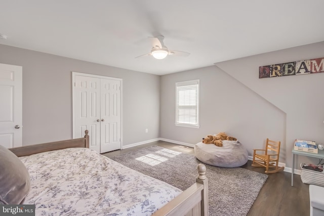 bedroom featuring a closet, dark wood finished floors, a ceiling fan, and baseboards