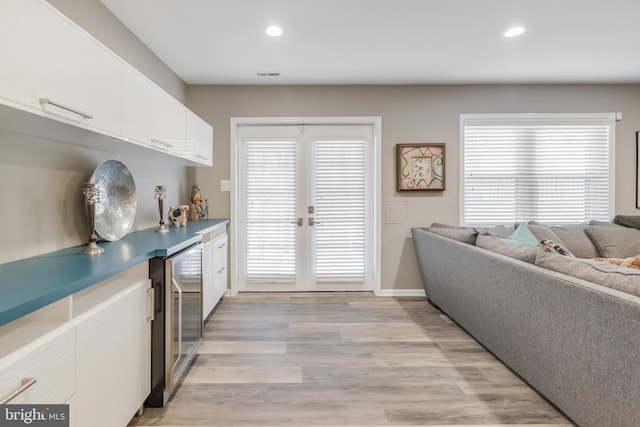 kitchen featuring light wood-style floors, wine cooler, white cabinetry, and recessed lighting