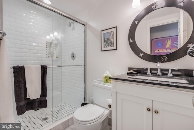 bathroom with toilet, a shower stall, and vanity