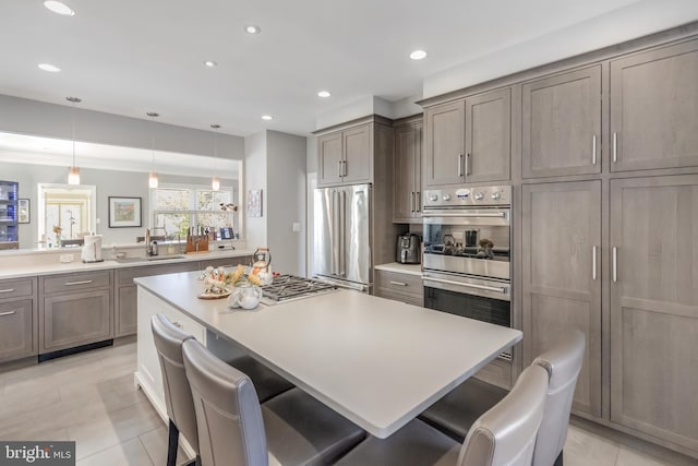 kitchen with stainless steel appliances, recessed lighting, light countertops, and a kitchen breakfast bar