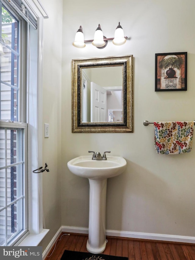 bathroom with baseboards and wood finished floors