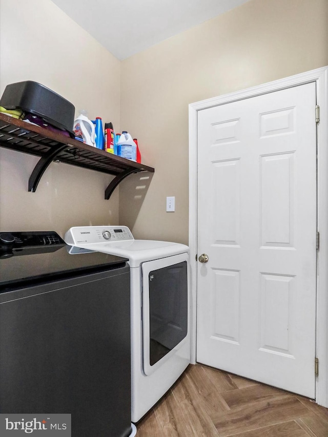 clothes washing area featuring laundry area, independent washer and dryer, and light wood-style flooring