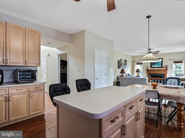 kitchen with light brown cabinets, a ceiling fan, open floor plan, light countertops, and dark wood finished floors