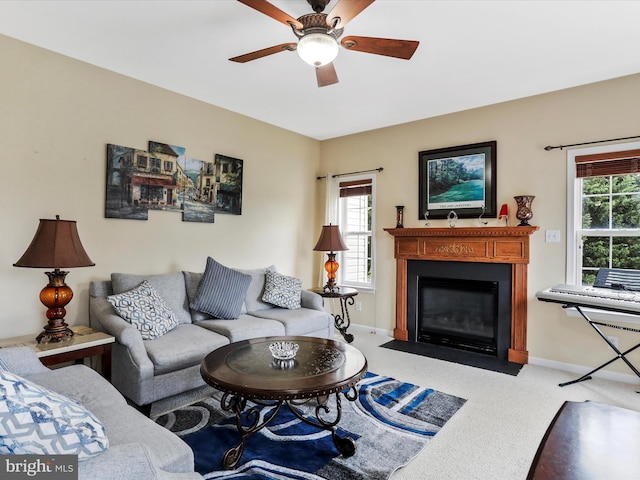 living area with a healthy amount of sunlight, a fireplace with flush hearth, light carpet, and baseboards