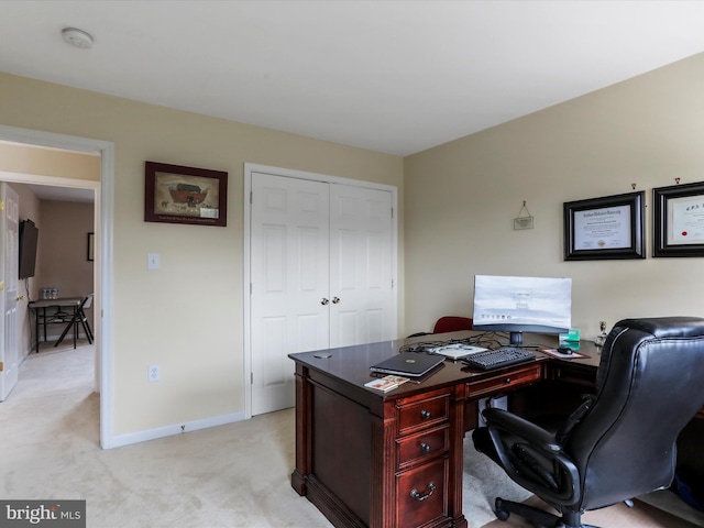 office area featuring light carpet and baseboards