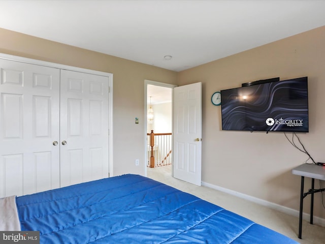 carpeted bedroom with a closet and baseboards