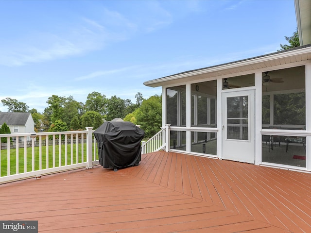 wooden deck with a sunroom and area for grilling