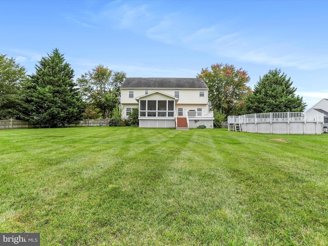 back of property featuring a sunroom, fence, and a yard